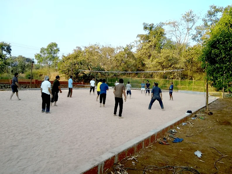 Guests playing volleyball on the sand court