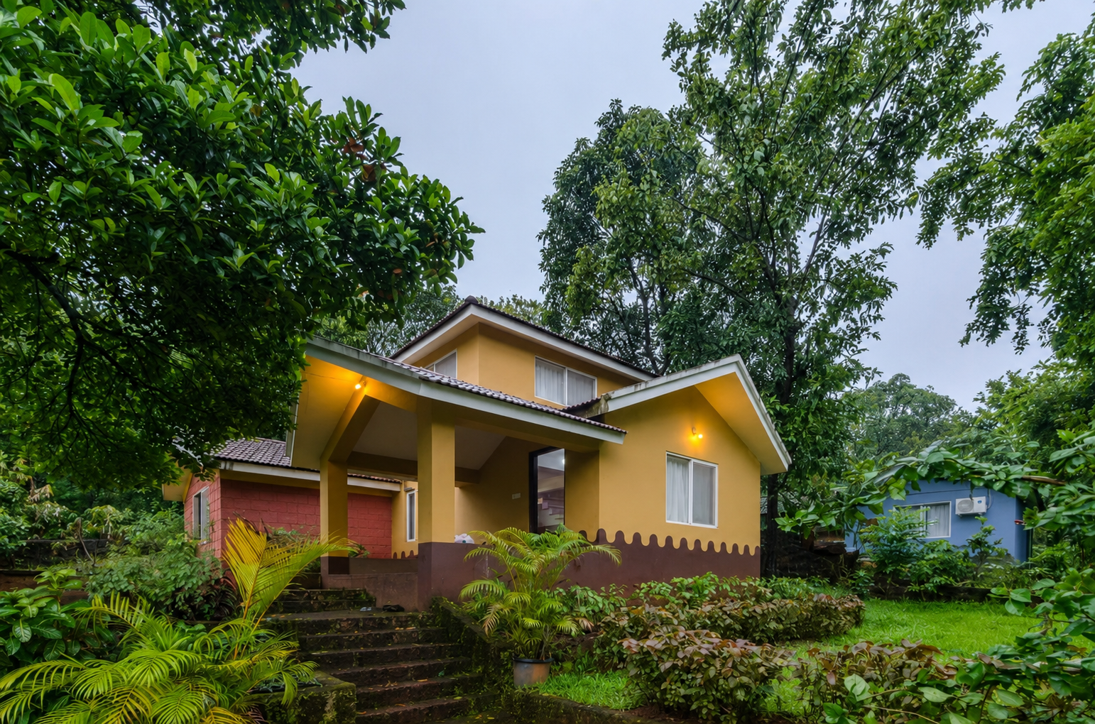 Yellow cottage surrounded by tropical greenery